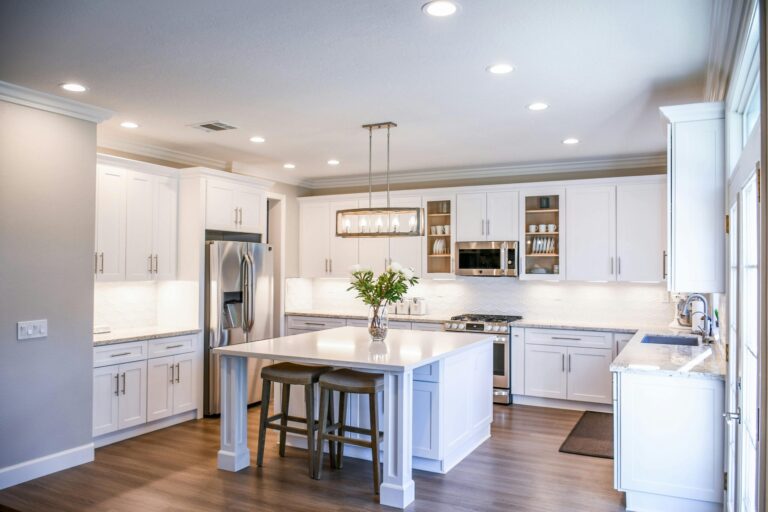 Chic kitchen featuring white cabinets, a large island, and modern appliances.